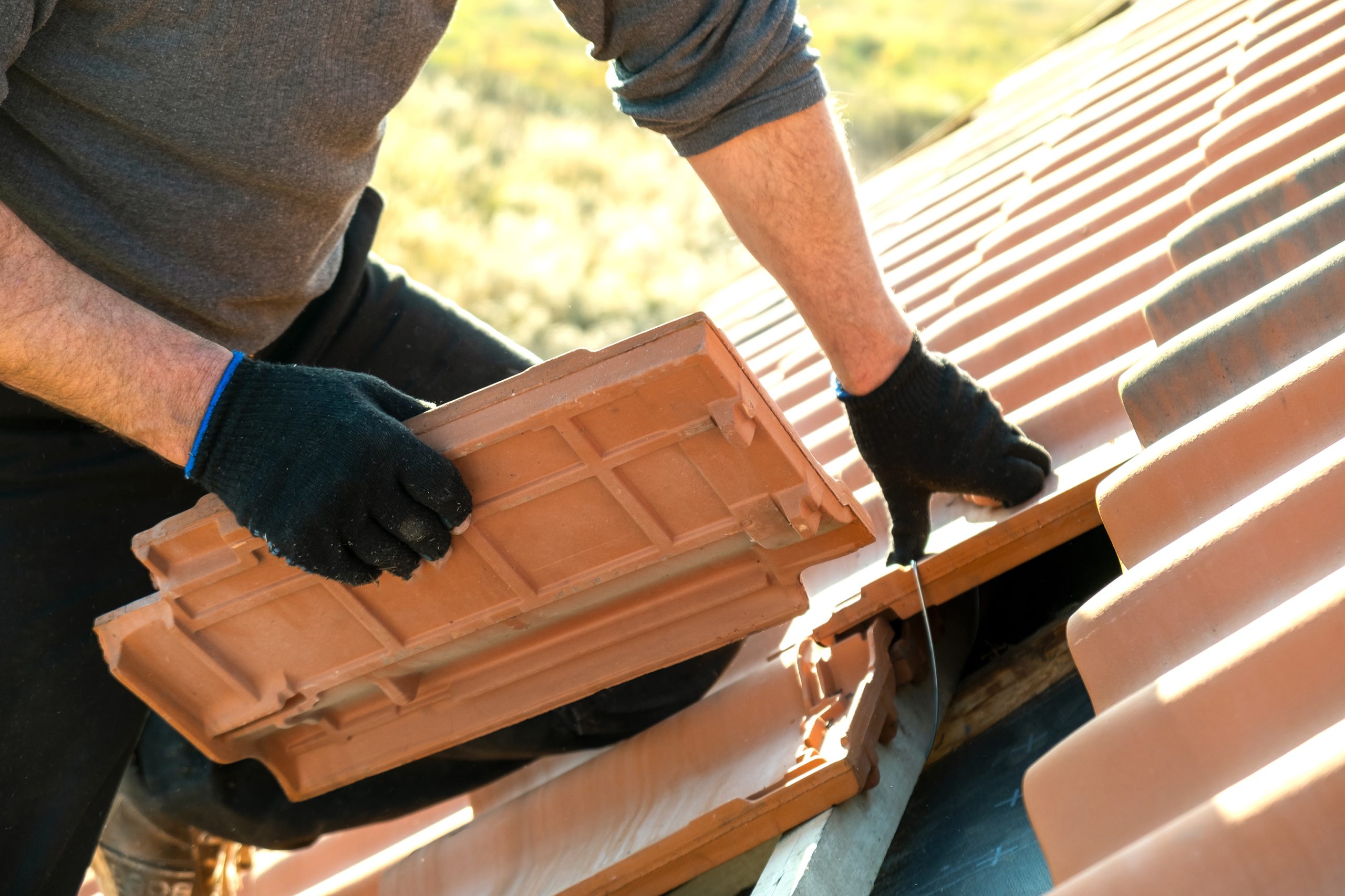 Roofer laying new roof tiles for repair Roofer laying new roof tiles for repair